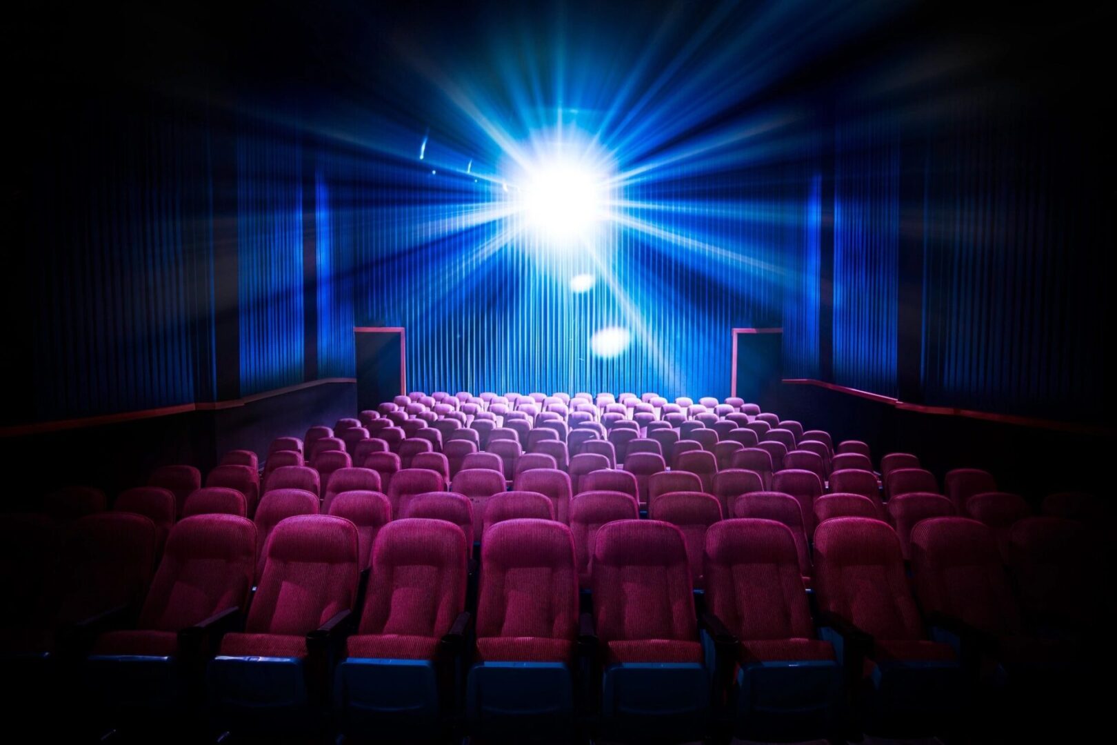 A theater with rows of seats and a projector.