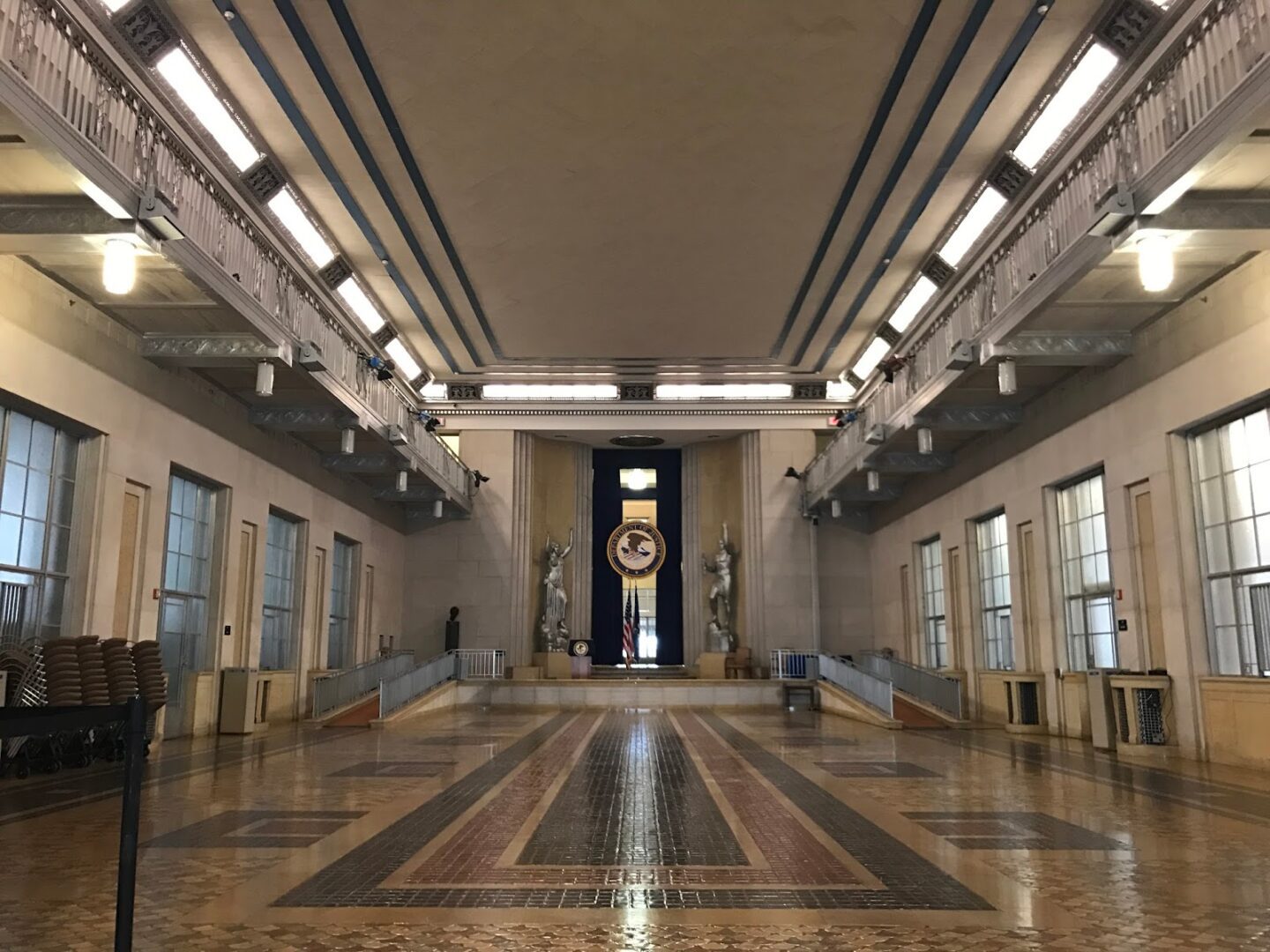 A large hall with marble floors and a statue of a man.