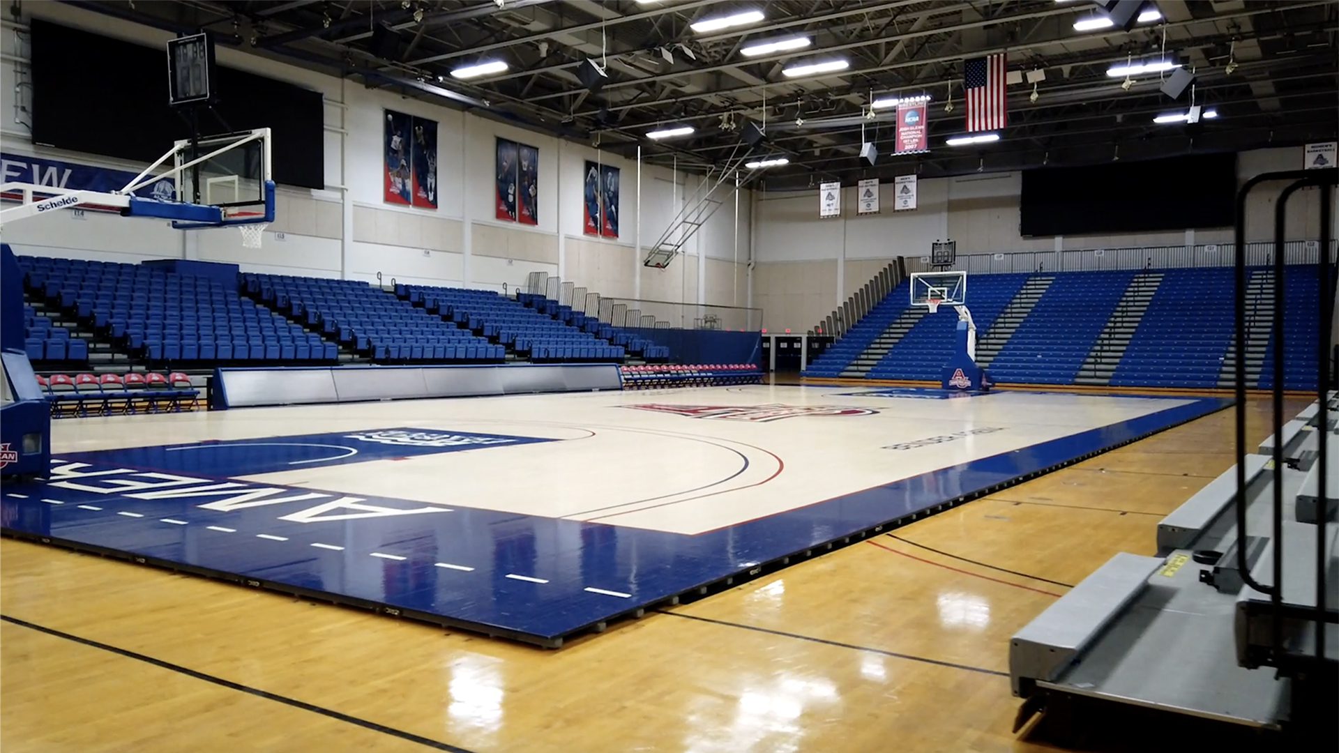 A basketball court with bleachers and a net.