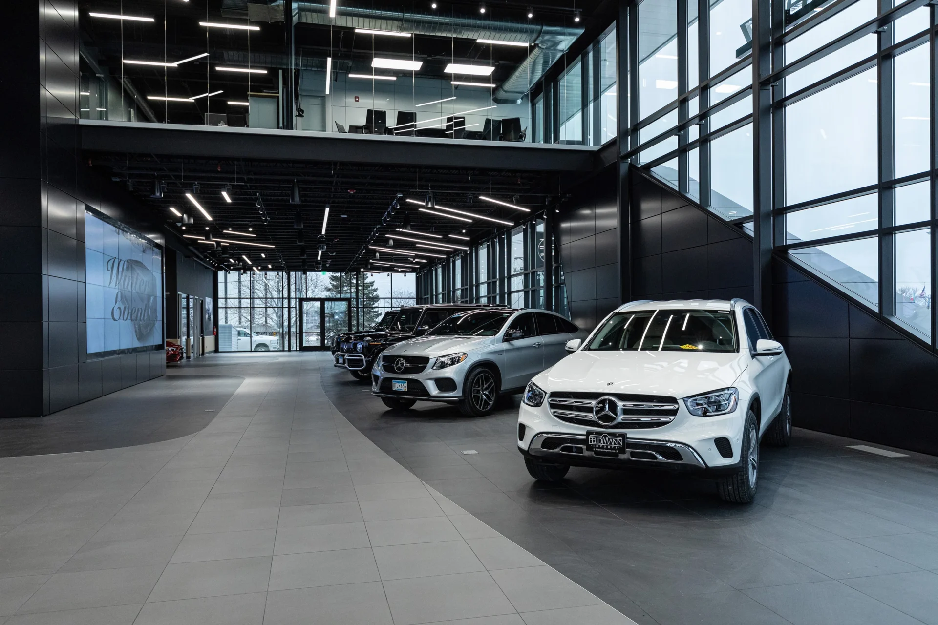 A car dealership with several cars parked in the showroom.
