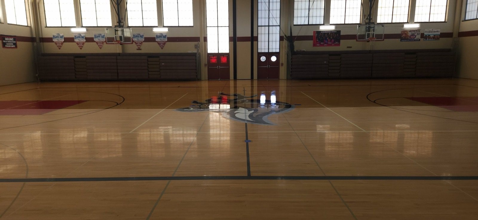 A gym with wooden floors and a mirror