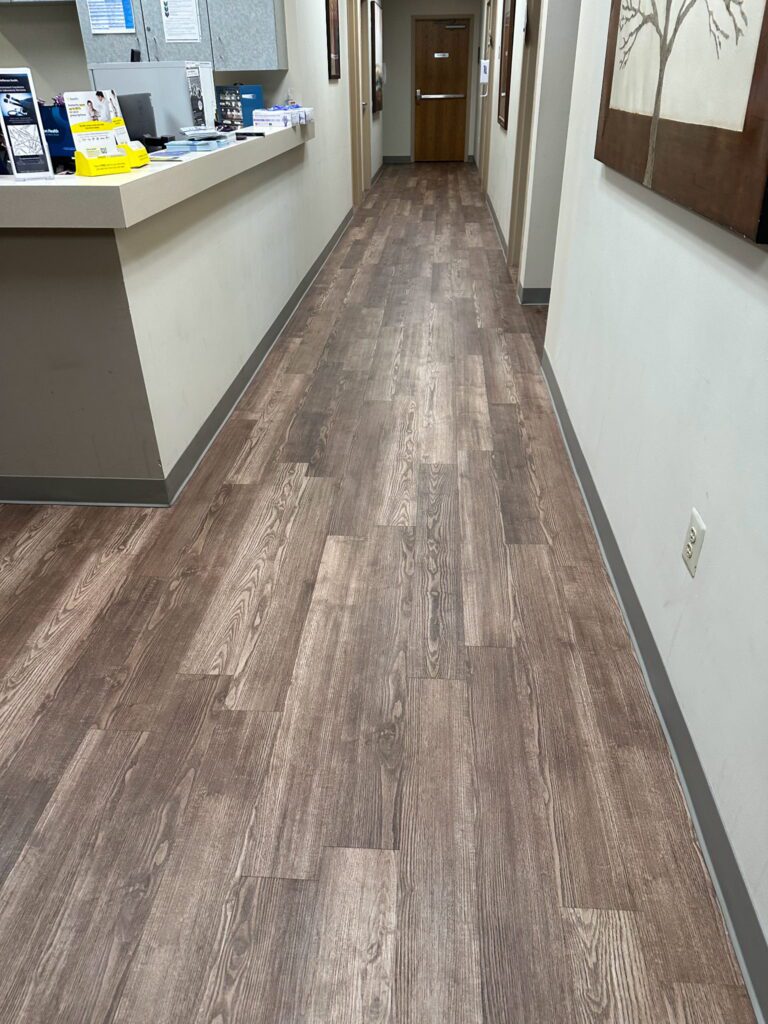A hallway with wooden floors and white walls.