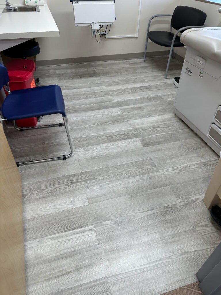 A kitchen with wooden floors and blue chair.