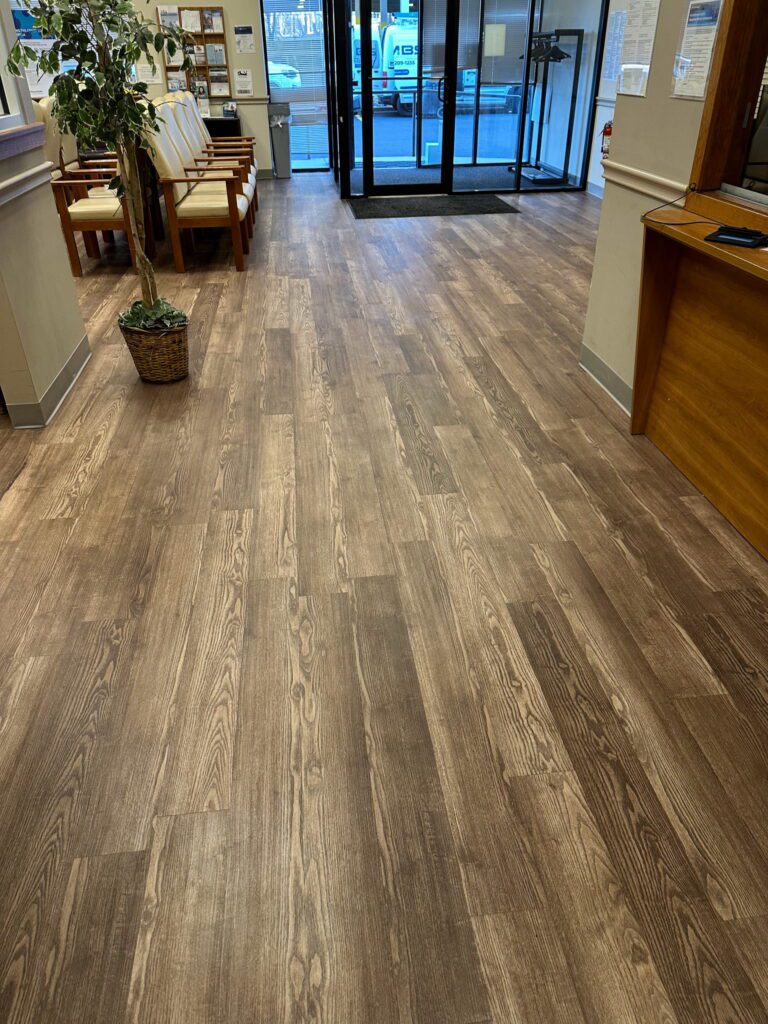 A hallway with wooden floors and chairs.