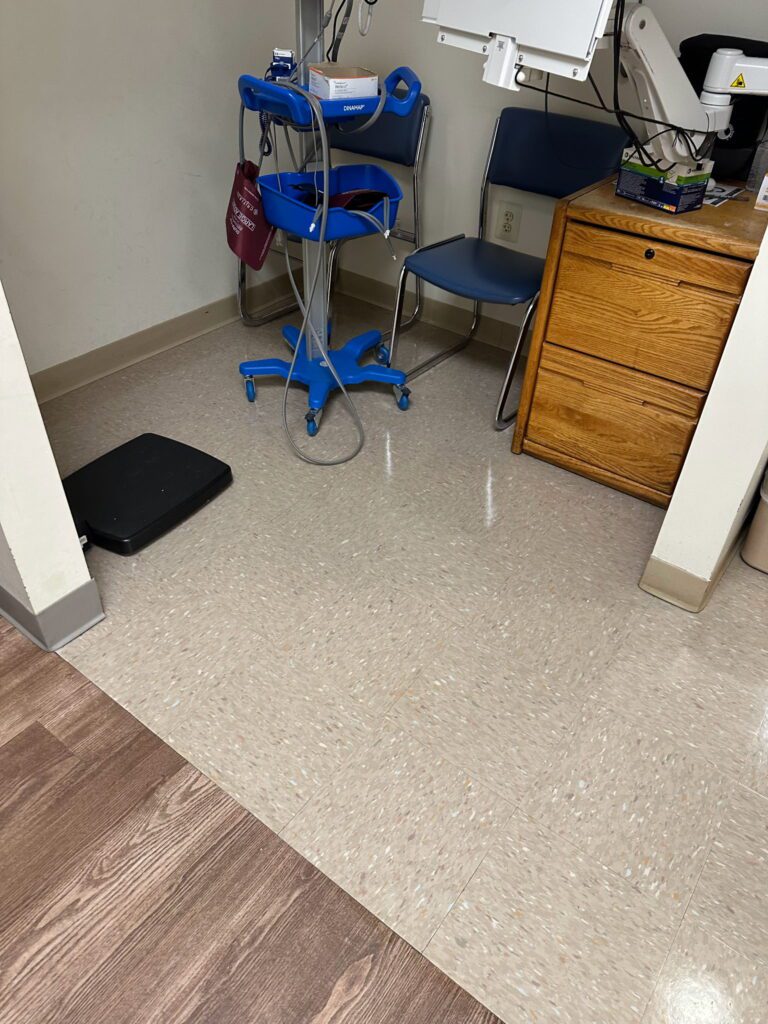 A room with a blue chair and a black floor