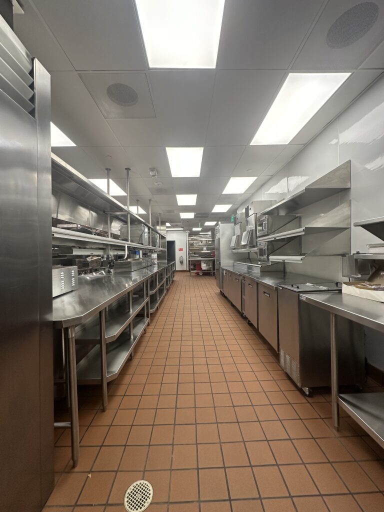 A kitchen with many stainless steel cabinets and counters.