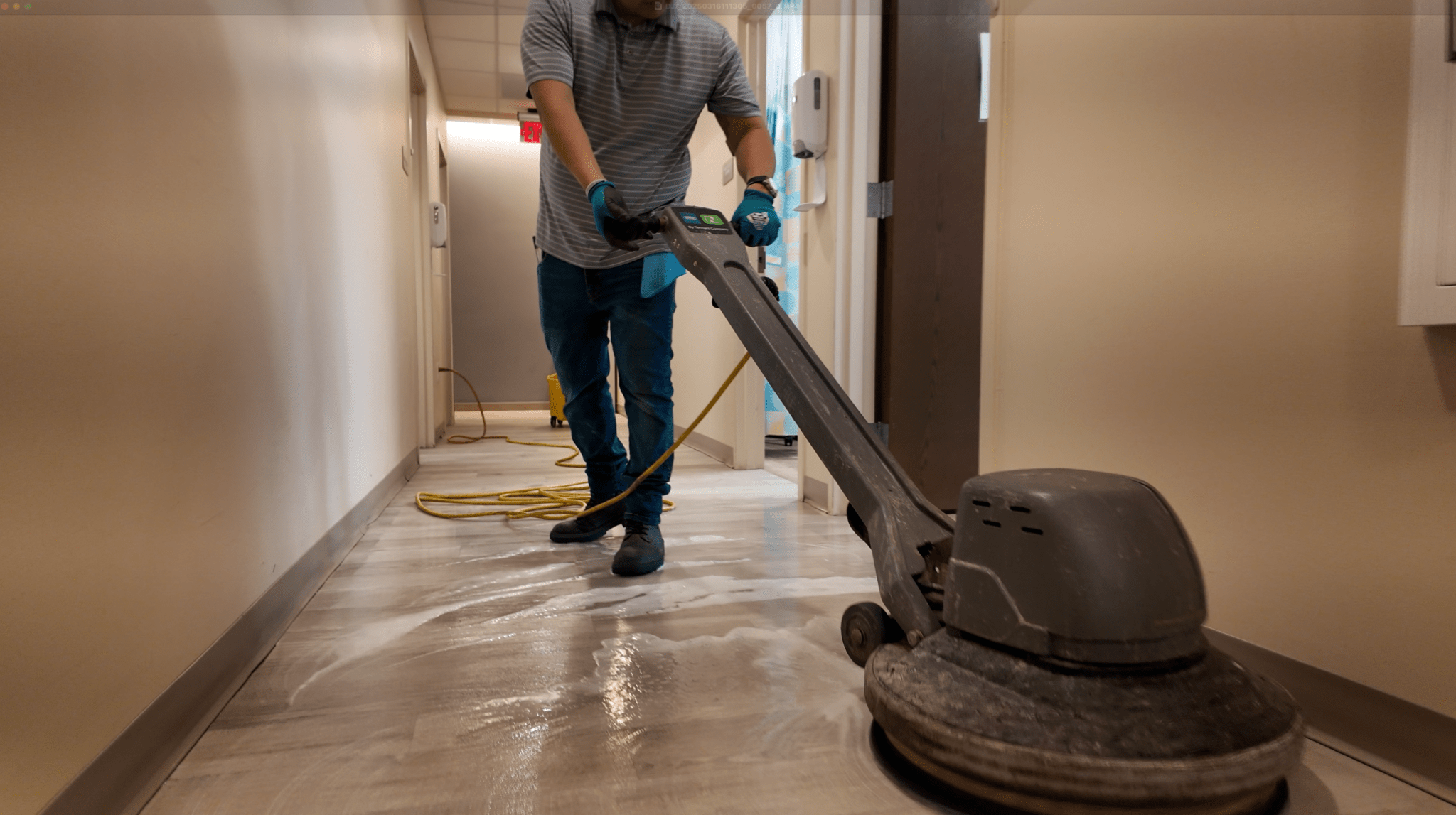 A man is cleaning the floor with a machine.